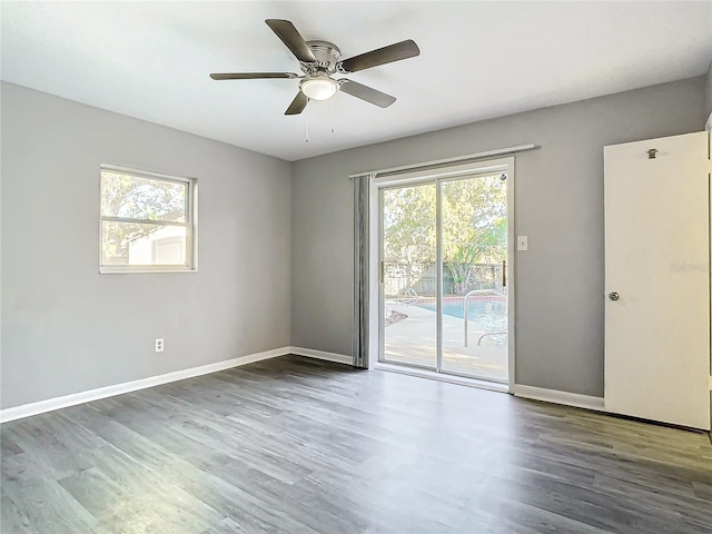 unfurnished room with ceiling fan and dark wood-type flooring