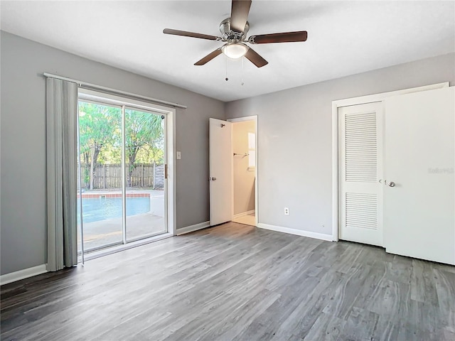 unfurnished bedroom featuring hardwood / wood-style flooring, ceiling fan, access to outside, and a closet