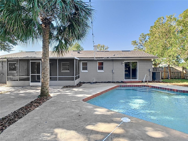 view of pool with cooling unit, a patio area, and a sunroom