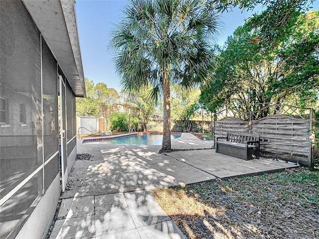 view of pool with a storage shed and a patio area