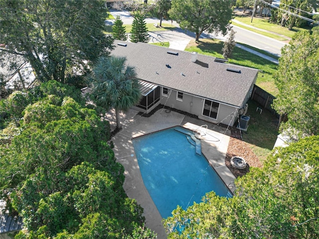 view of pool featuring a sunroom, a patio area, and central air condition unit