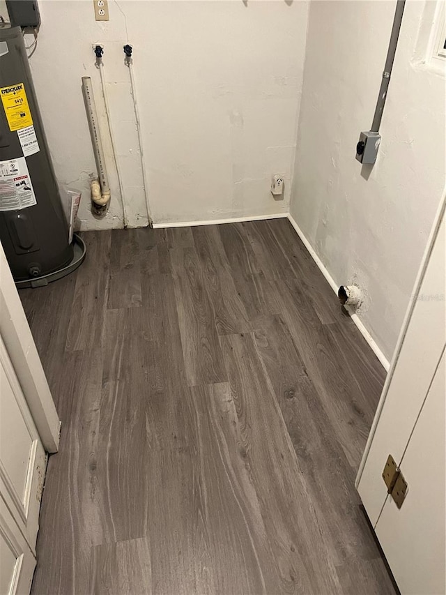 washroom with electric water heater and dark wood-type flooring