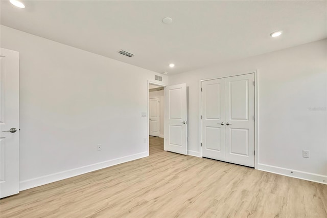 unfurnished bedroom featuring a closet and light wood-type flooring