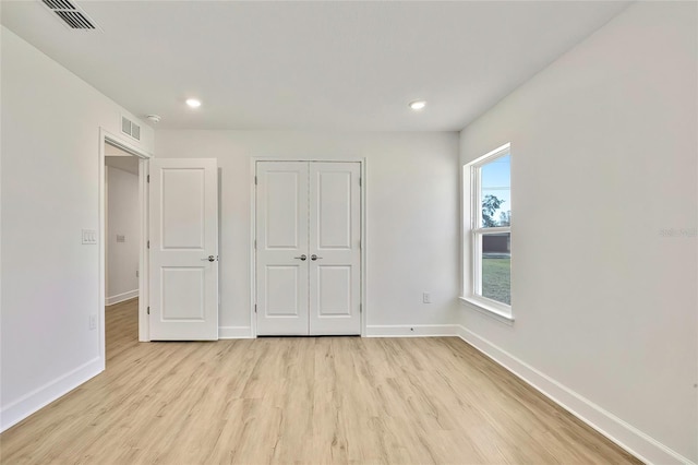 unfurnished bedroom featuring light hardwood / wood-style flooring and a closet