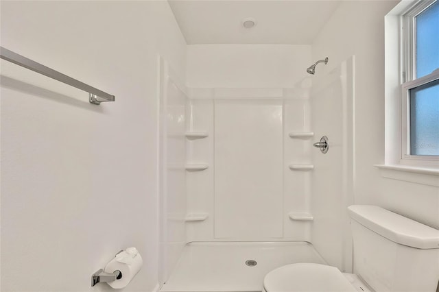 bathroom featuring a shower and toilet