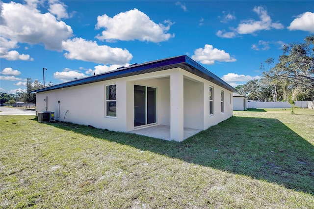 view of side of home with a yard, a patio, and central AC unit