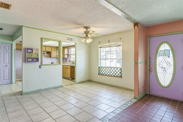 foyer entrance with light tile patterned floors, a textured ceiling, plenty of natural light, and ceiling fan