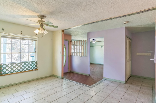 unfurnished room featuring ceiling fan, light tile patterned flooring, and a textured ceiling