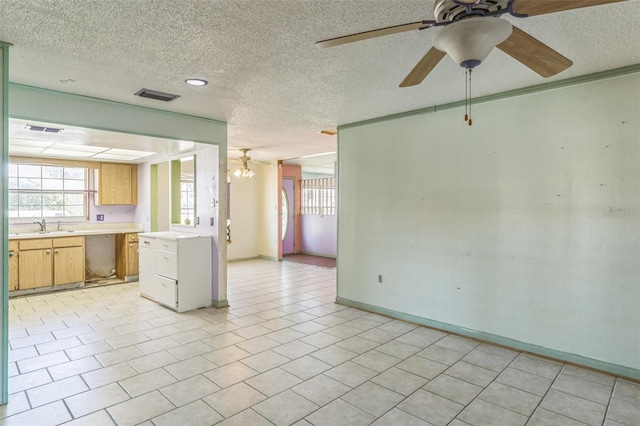 tiled empty room with a textured ceiling, ceiling fan, and sink