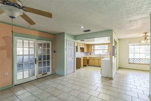 kitchen featuring ceiling fan, french doors, light tile patterned floors, and a textured ceiling