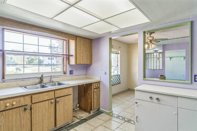 kitchen featuring ceiling fan, sink, and light tile patterned floors