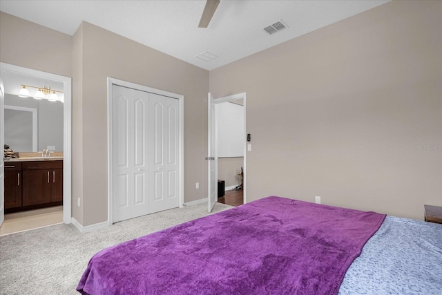 bedroom featuring light carpet, ceiling fan, sink, connected bathroom, and a closet