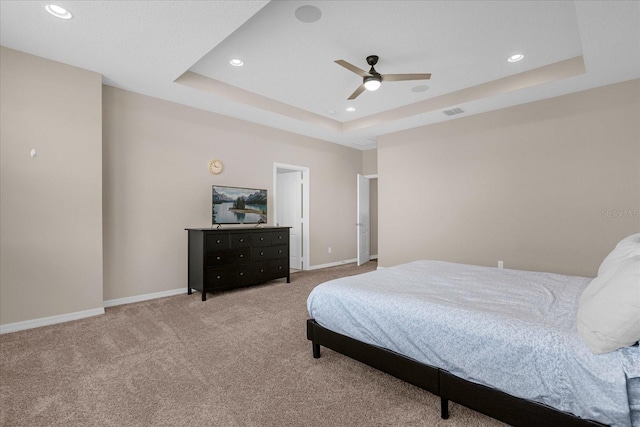 bedroom featuring a tray ceiling, ceiling fan, and carpet flooring