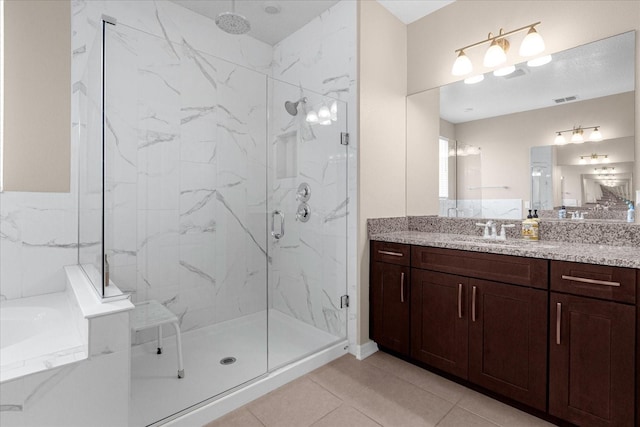 bathroom with tile patterned flooring, vanity, and walk in shower