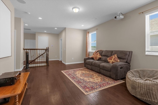 living room featuring a textured ceiling, a wealth of natural light, and dark hardwood / wood-style floors