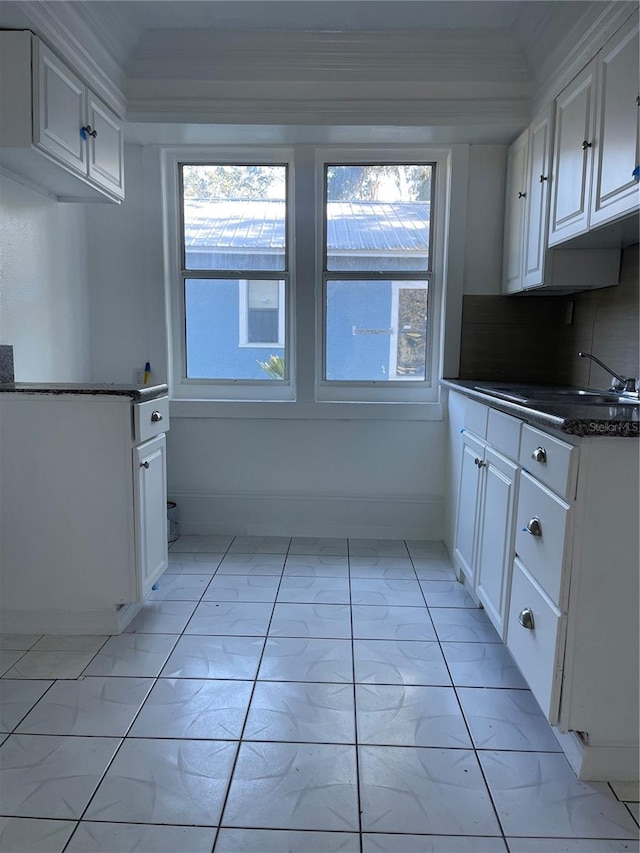 kitchen featuring white cabinets, decorative backsplash, and sink