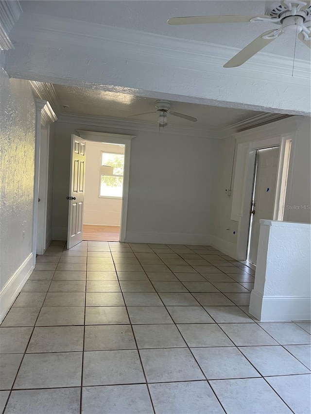 unfurnished room with light tile patterned flooring and crown molding