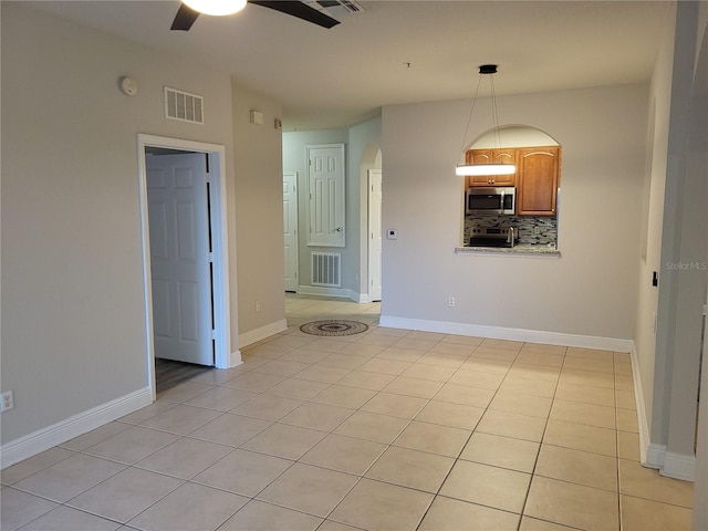 empty room featuring ceiling fan and light tile patterned floors