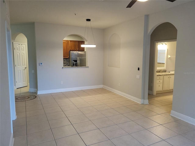 tiled empty room with ceiling fan and sink