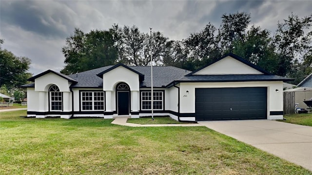 ranch-style home with a garage and a front lawn