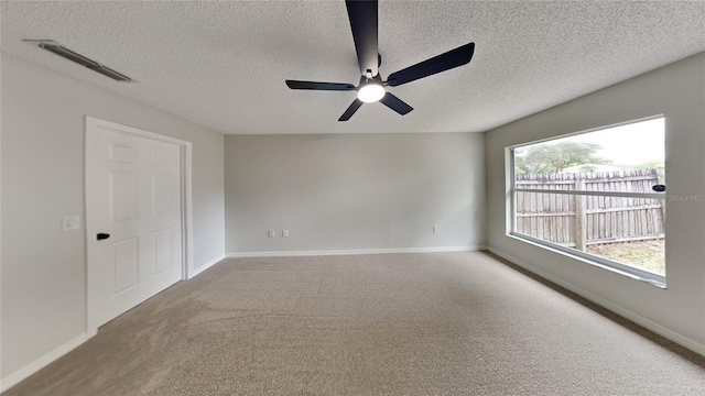 unfurnished room with carpet flooring, ceiling fan, a healthy amount of sunlight, and a textured ceiling