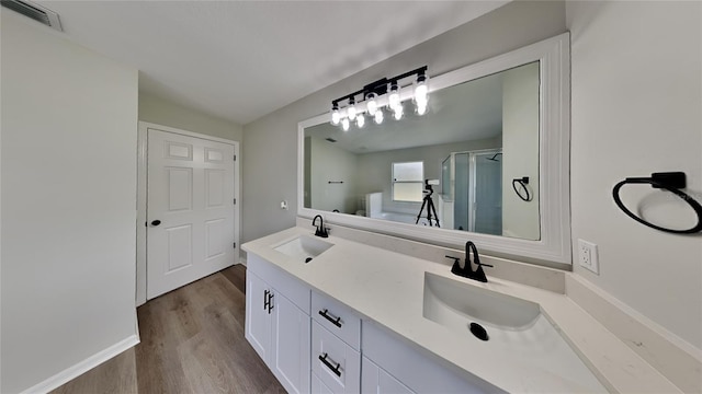 bathroom featuring hardwood / wood-style floors, vanity, and a shower with shower door