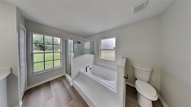 bathroom featuring hardwood / wood-style floors, toilet, and plus walk in shower