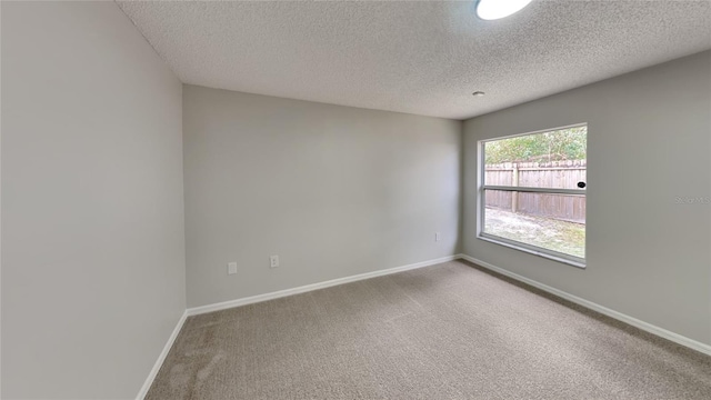 spare room with a textured ceiling and carpet floors