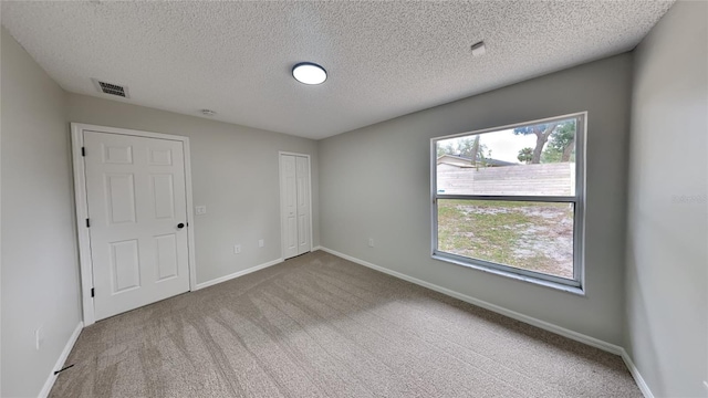 unfurnished bedroom with carpet flooring and a textured ceiling