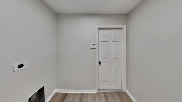 laundry room with hookup for an electric dryer and light wood-type flooring