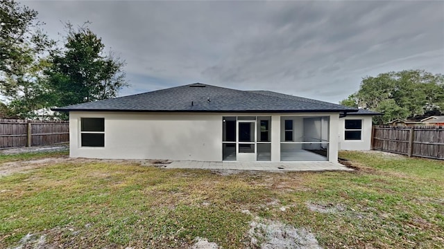 rear view of property with a lawn and a patio area