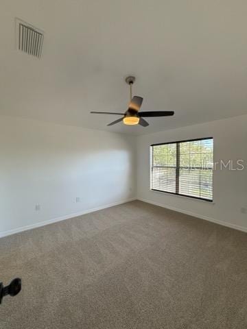 spare room featuring carpet floors and ceiling fan