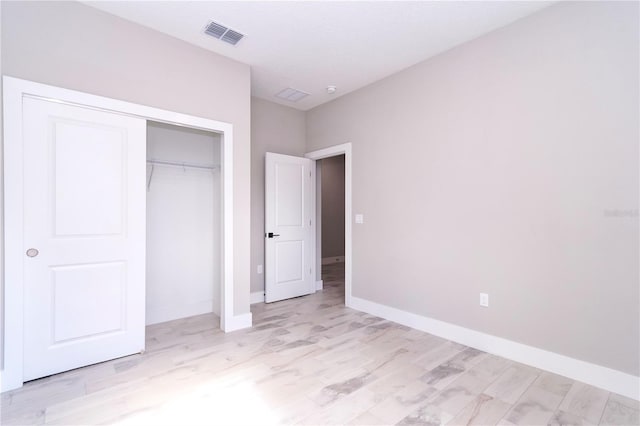 unfurnished bedroom featuring light hardwood / wood-style flooring and a closet