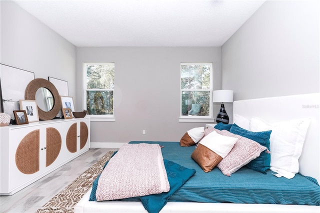 bedroom with wood-type flooring and multiple windows