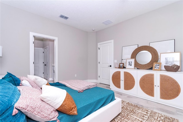 bedroom with hardwood / wood-style flooring and a textured ceiling