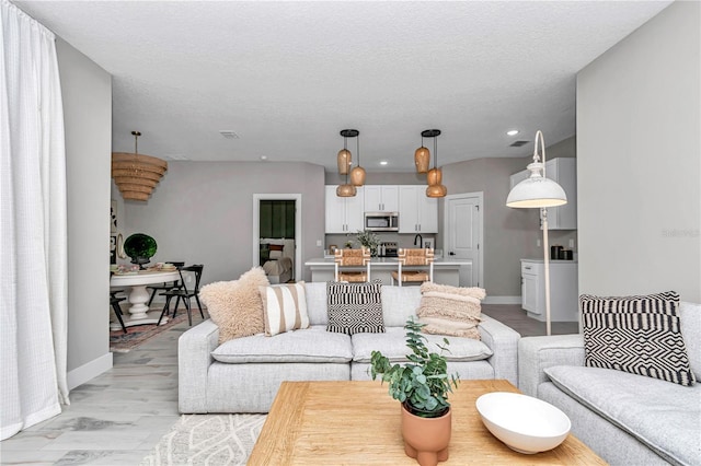 13516 SW 78th Pl, Dunnellon, FL 34432 - living room with baseboards, recessed lighting, light wood-type flooring, and a textured ceiling