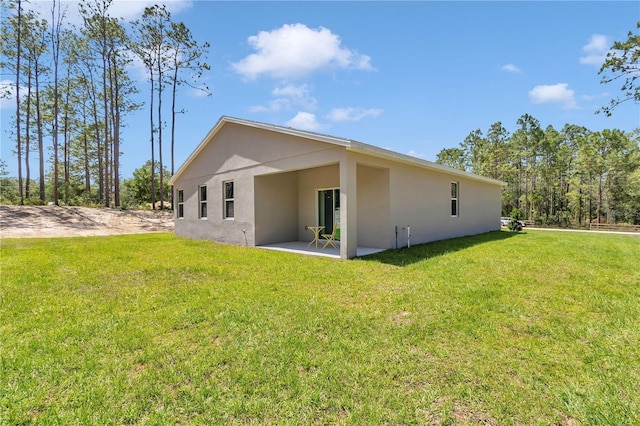 13516 SW 78th Pl, Dunnellon, FL 34432 - back of property with stucco siding, a lawn, and a patio