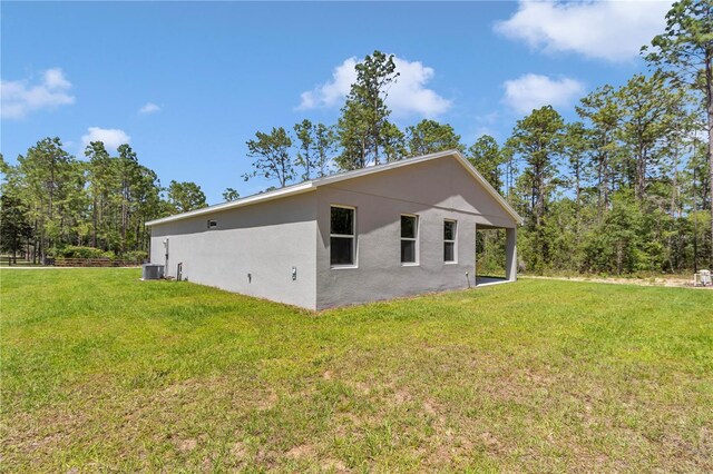 13516 SW 78th Pl, Dunnellon, FL 34432 - view of side of property featuring stucco siding, a yard, and cooling unit