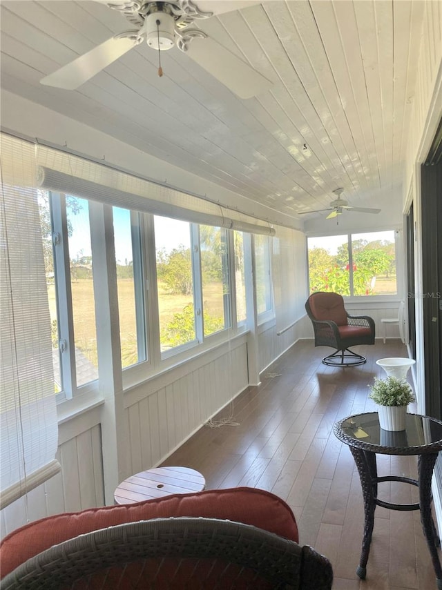 sunroom with ceiling fan, a healthy amount of sunlight, and wooden ceiling