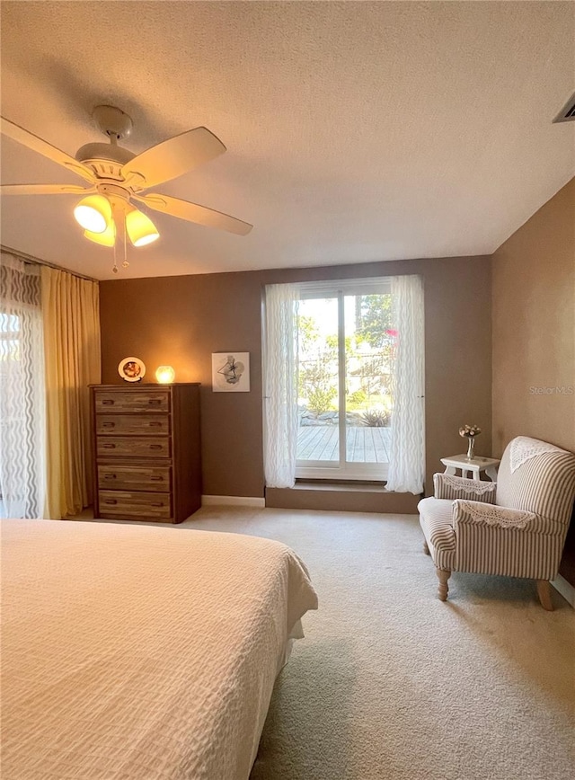 bedroom featuring light carpet, a textured ceiling, and ceiling fan