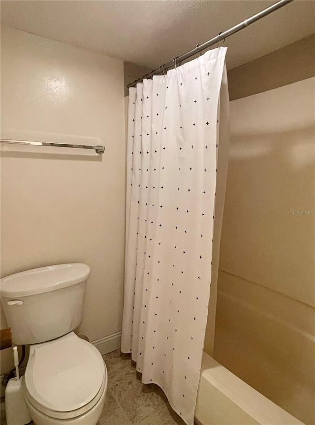 bathroom featuring tile patterned floors, toilet, and shower / bath combination with curtain