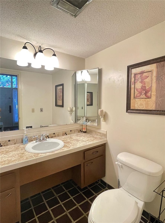 bathroom featuring vanity, toilet, and a textured ceiling