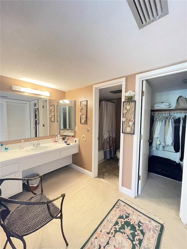 bathroom featuring vanity, a textured ceiling, and toilet