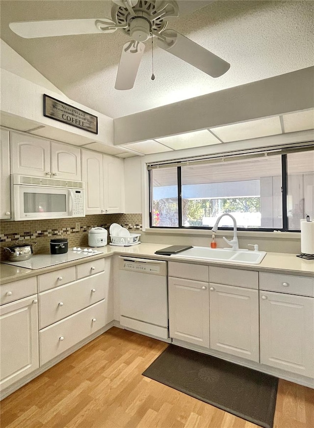 kitchen featuring decorative backsplash, white appliances, sink, light hardwood / wood-style floors, and white cabinetry