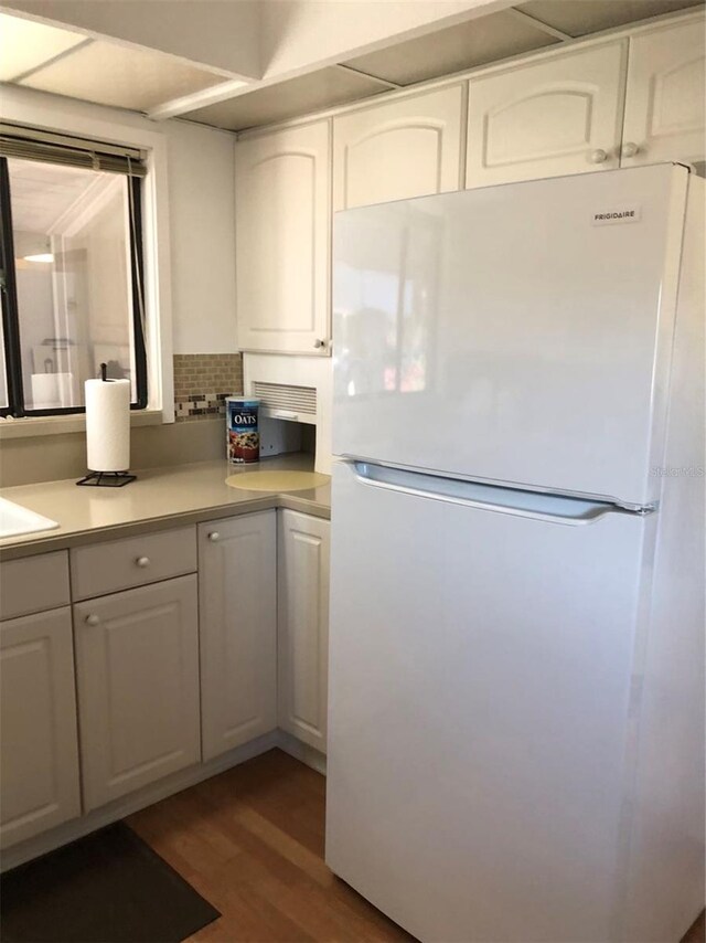 kitchen featuring white cabinetry, dark hardwood / wood-style floors, and white refrigerator