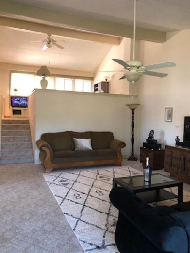 carpeted living room featuring lofted ceiling with beams