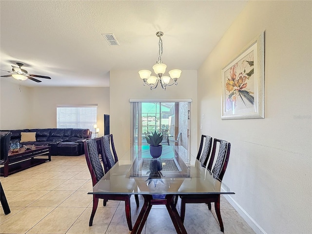 dining room with ceiling fan with notable chandelier, a wealth of natural light, and light tile patterned flooring