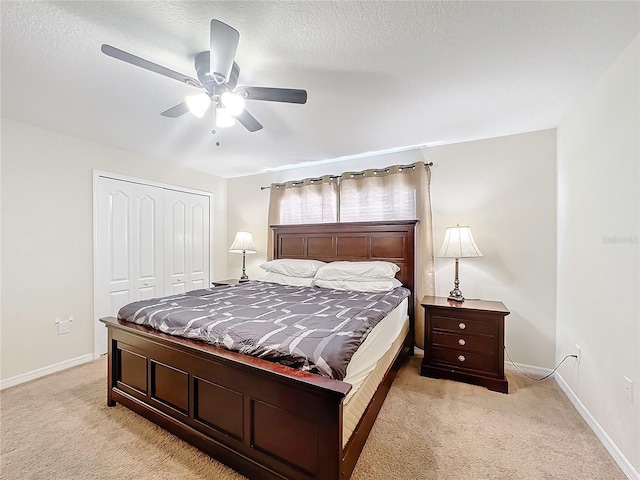 carpeted bedroom featuring a textured ceiling, a closet, and ceiling fan