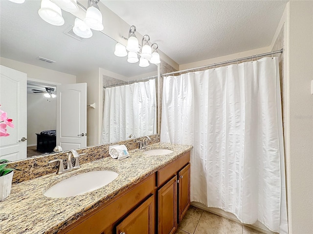 bathroom featuring tile patterned flooring, vanity, and a textured ceiling