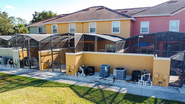 back of property with a lawn and central air condition unit